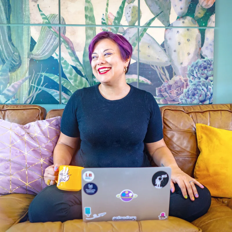 Hazel Quimpo on the couch with her laptop, mid-laugh