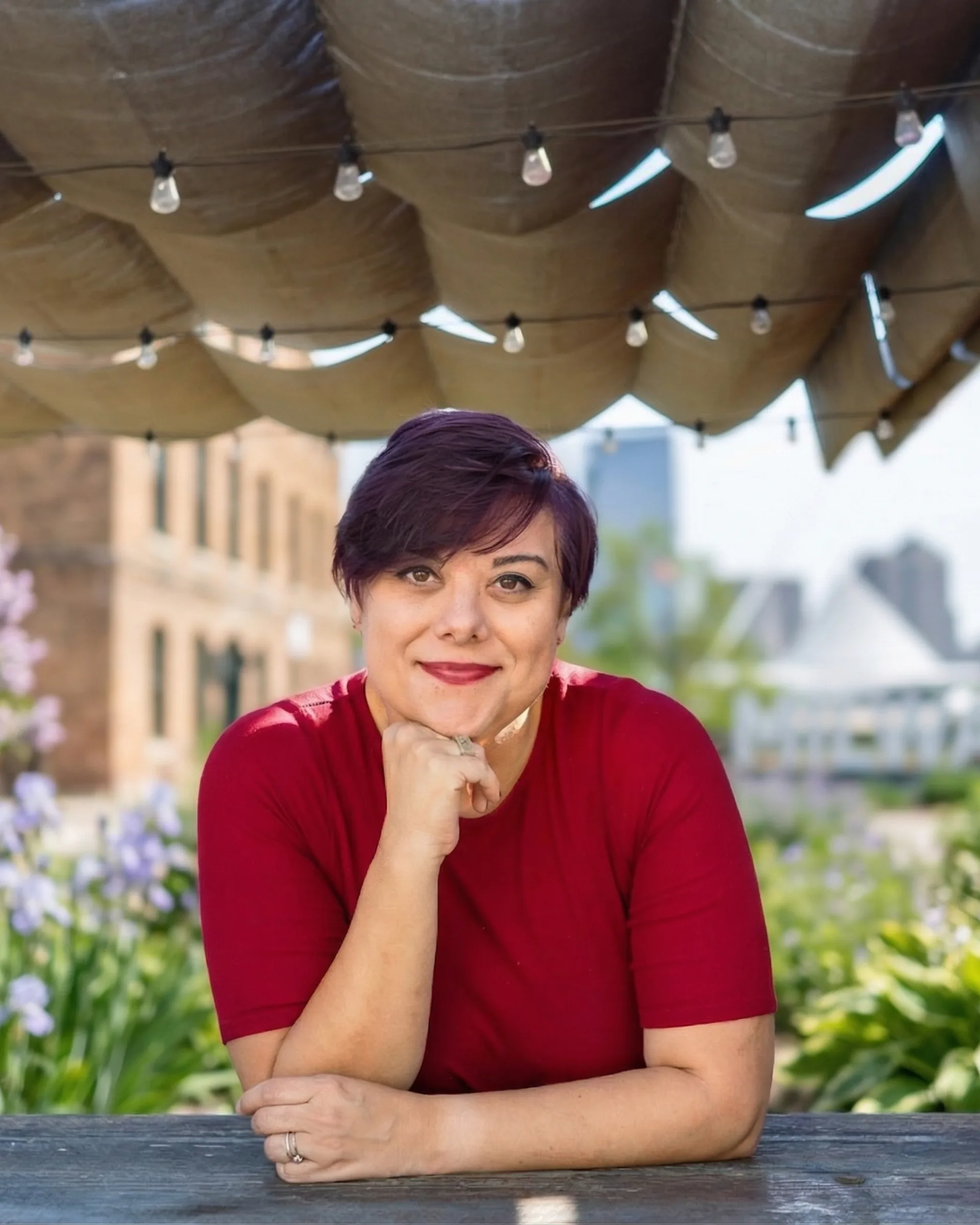 Hazel Quimpo at a rooftop patio with string lights and city skyline — marketing strategist and AI teacher